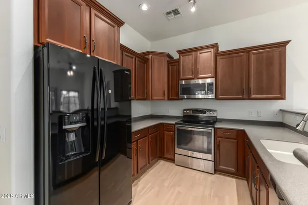 a kitchen with stainless steel appliances granite countertop a refrigerator stove and sink