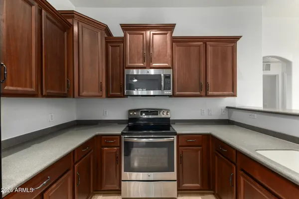 a kitchen with stainless steel appliances granite countertop wooden cabinets a stove top oven a sink and dishwasher
