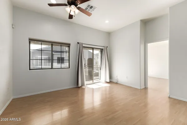 a view of an empty room with a window and wooden floor