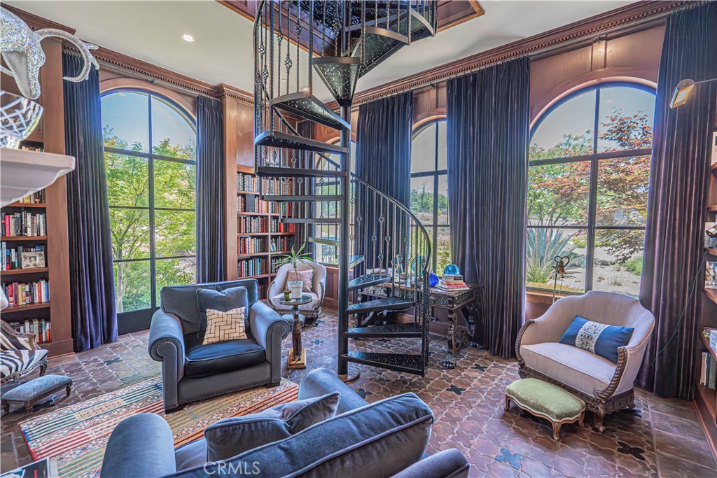 3030 Templeton Road Templeton, CA 93465 - Photo 22 of 75 The downstairs library is filled with natural light and features a captivating spiral staircase that leads to an upper-level library seating area — perfect for quiet reading or reflection.