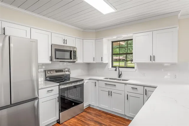 a kitchen with white cabinets and white appliances