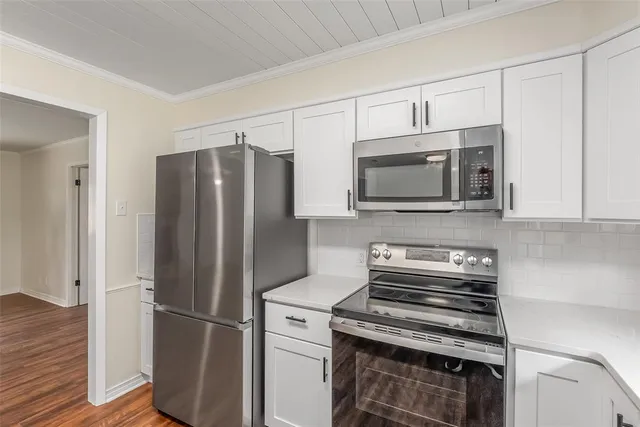 a kitchen with stainless steel appliances a refrigerator microwave and stove top oven