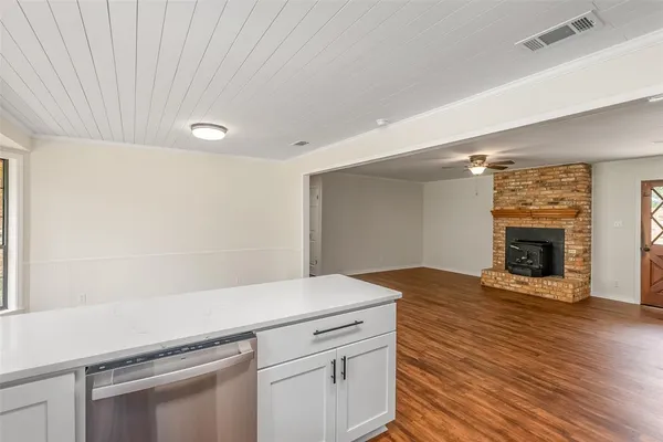 a view of a livingroom with wooden floor and a fireplace