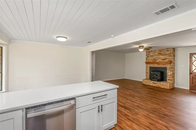 a view of a livingroom with wooden floor and a fireplace