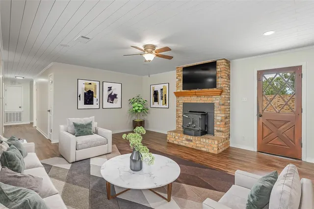 a living room with furniture a flat screen tv and a fireplace