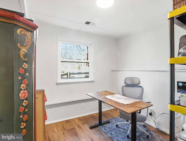 a view of a workspace with furniture and wooden floor