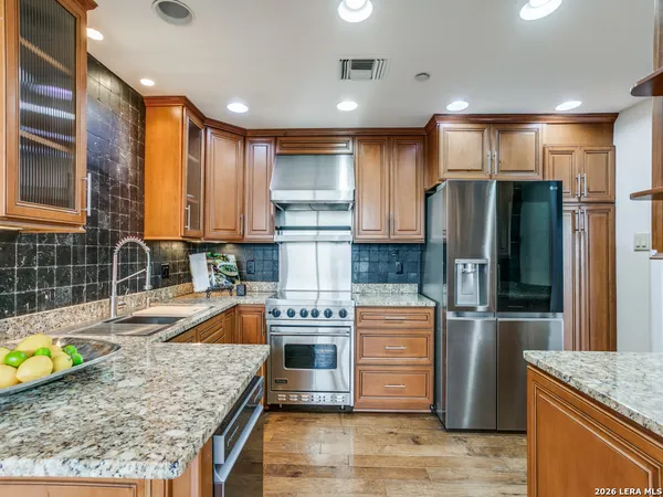 a kitchen with stainless steel appliances granite countertop a sink stove and refrigerator