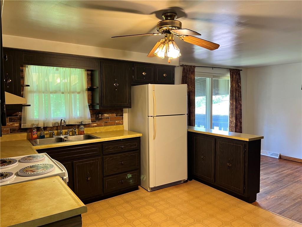 880 Pizza Barn Road Blairsville, PA 15717 - Photo 18 of 44 a kitchen with a refrigerator a stove a sink and a dining table with wooden floor