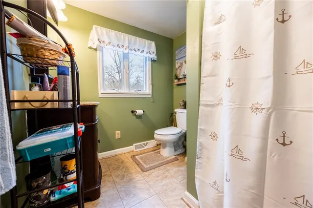 a bathroom with a toilet and a shower curtain