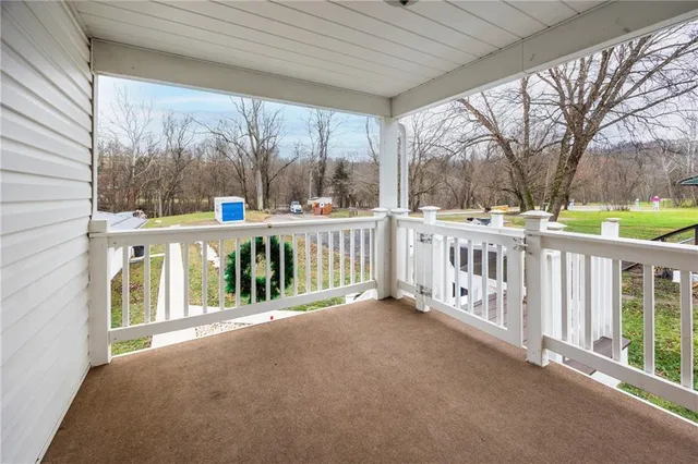a view of a balcony with wooden floor and fence
