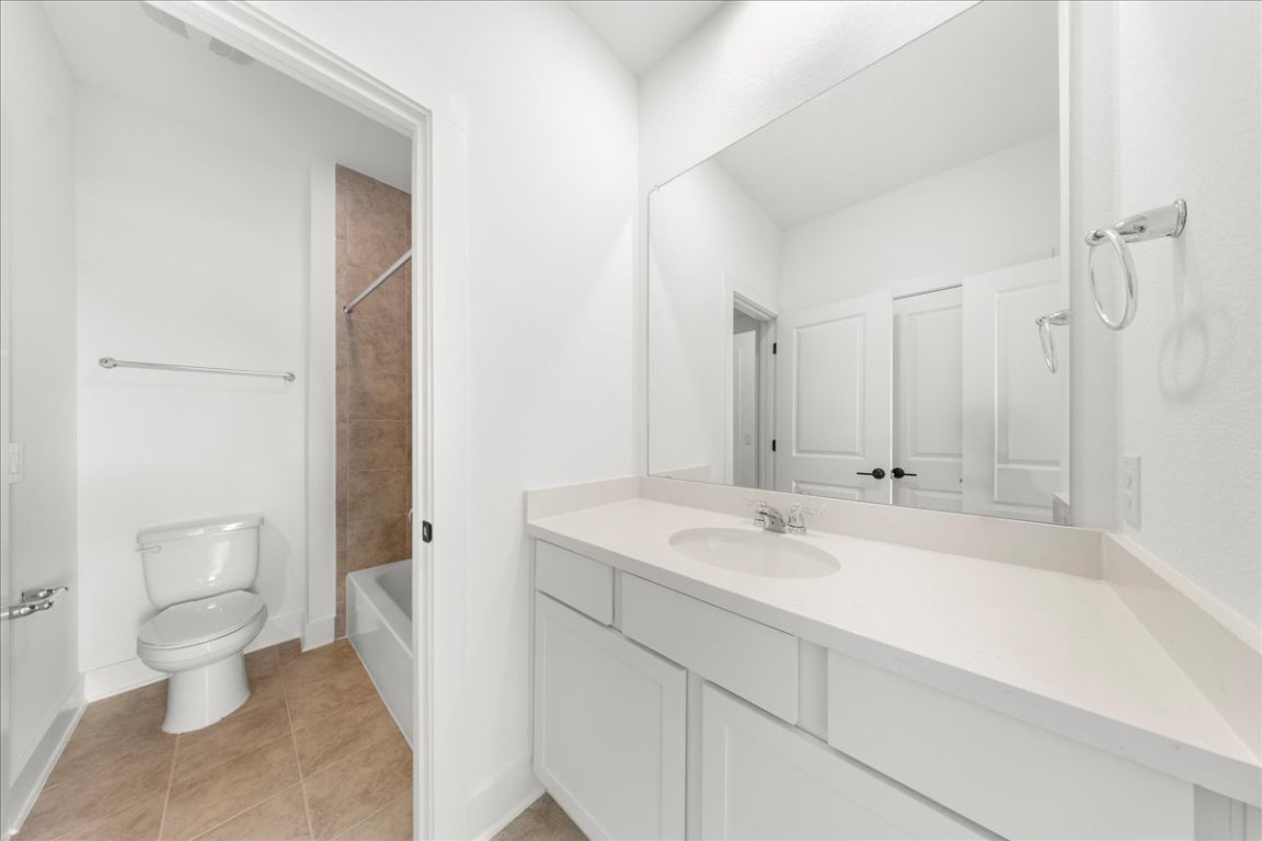 8700 Olmsted Way Austin, TX 78744 - Photo 30 of 40 Full bath featuring light tile patterned floors, vanity, and shower combination