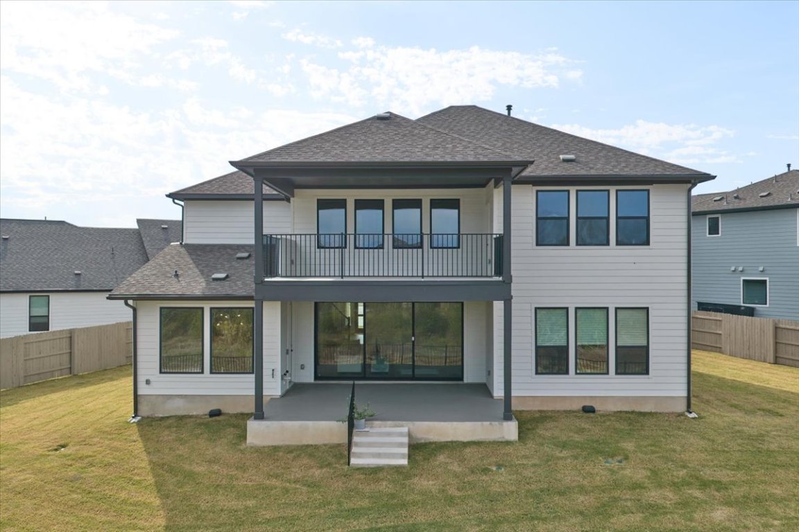 8700 Olmsted Way Austin, TX 78744 - Photo 4 of 40 Back of house with a fenced backyard, a patio, roof with shingles, and a balcony