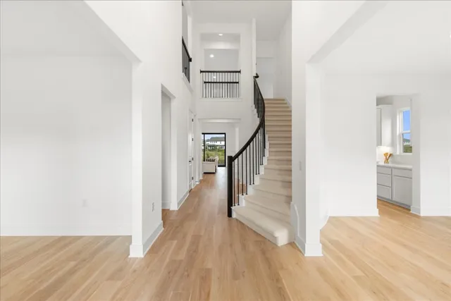 a view of a hallway with wooden floor and staircase