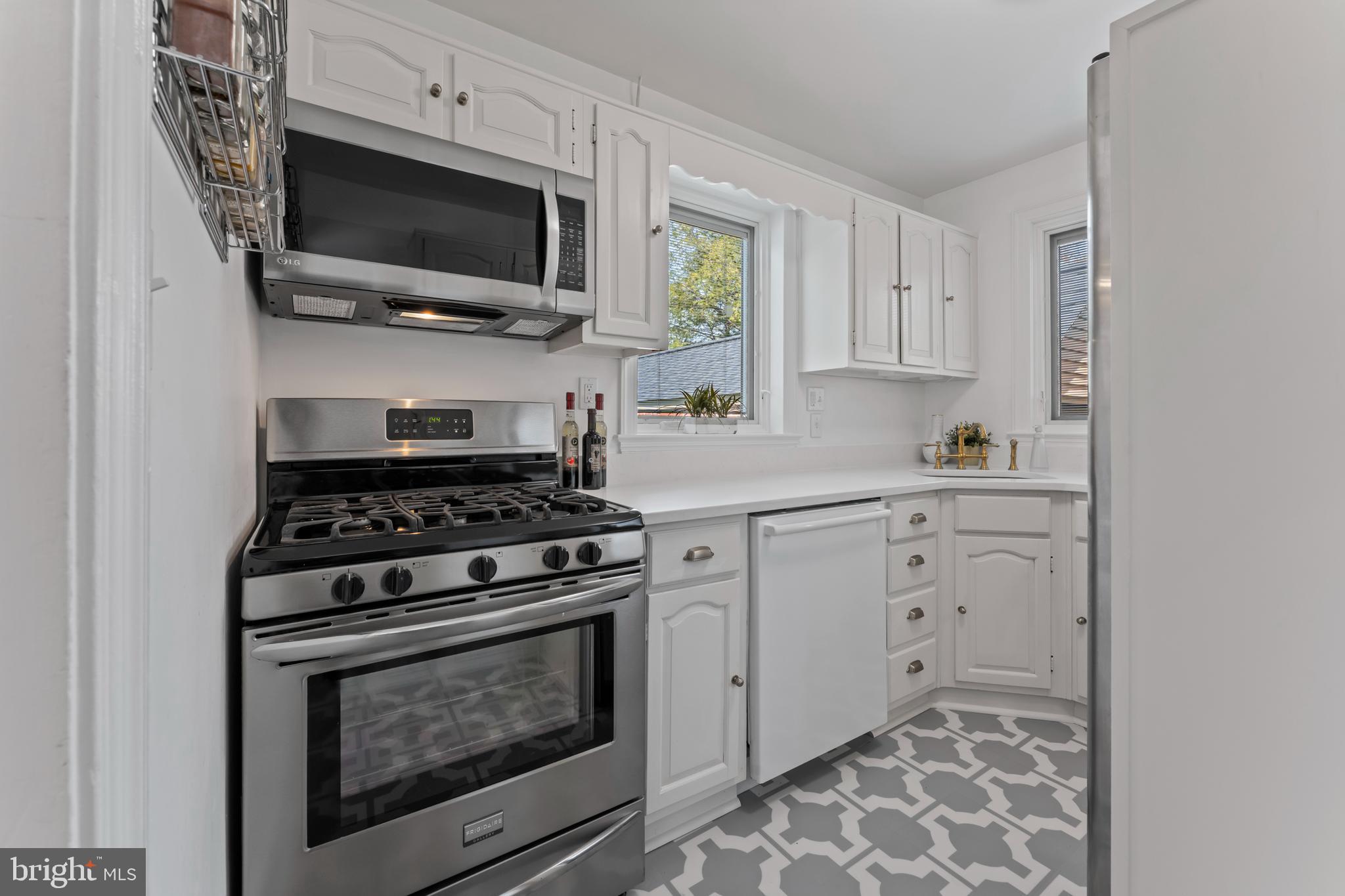 9906 Rogart Road Silver Spring, MD 20901 - Photo 17 of 68 a kitchen with cabinets stainless steel appliances and wooden floor