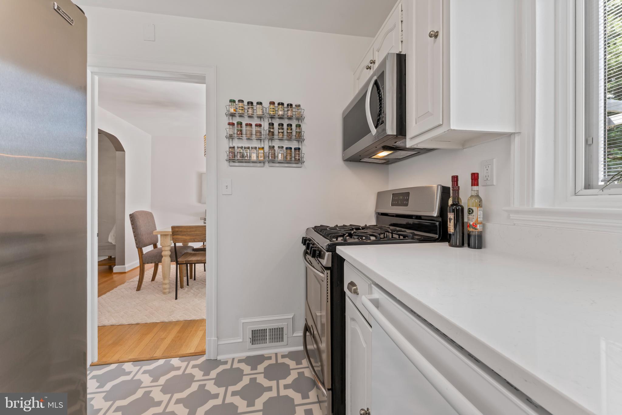 9906 Rogart Road Silver Spring, MD 20901 - Photo 19 of 68 a kitchen with stainless steel appliances granite countertop a stove a sink and a refrigerator