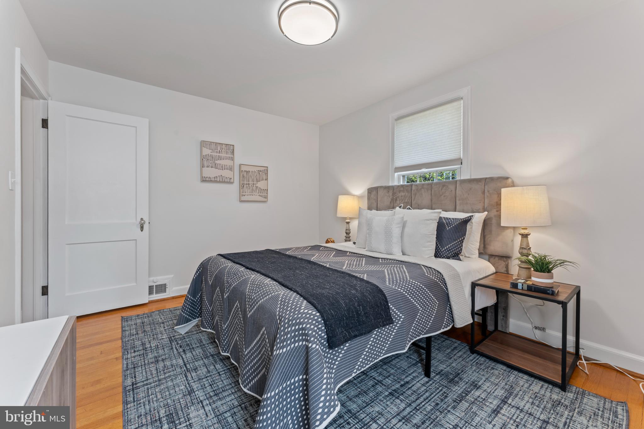 9906 Rogart Road Silver Spring, MD 20901 - Photo 29 of 68 a bed room with a bed and a lamp