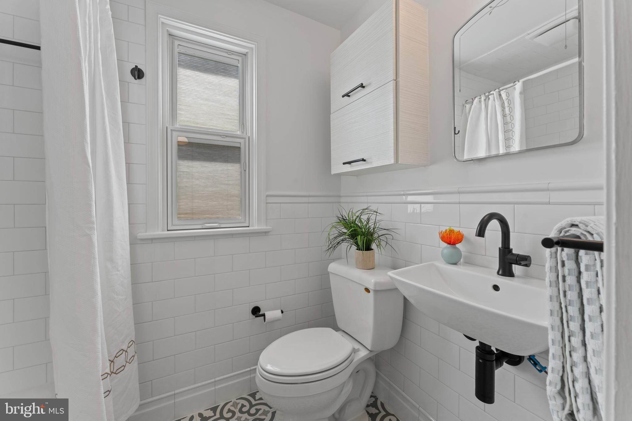 9906 Rogart Road Silver Spring, MD 20901 - Photo 30 of 68 a bathroom with a sink mirror vanity and toilet