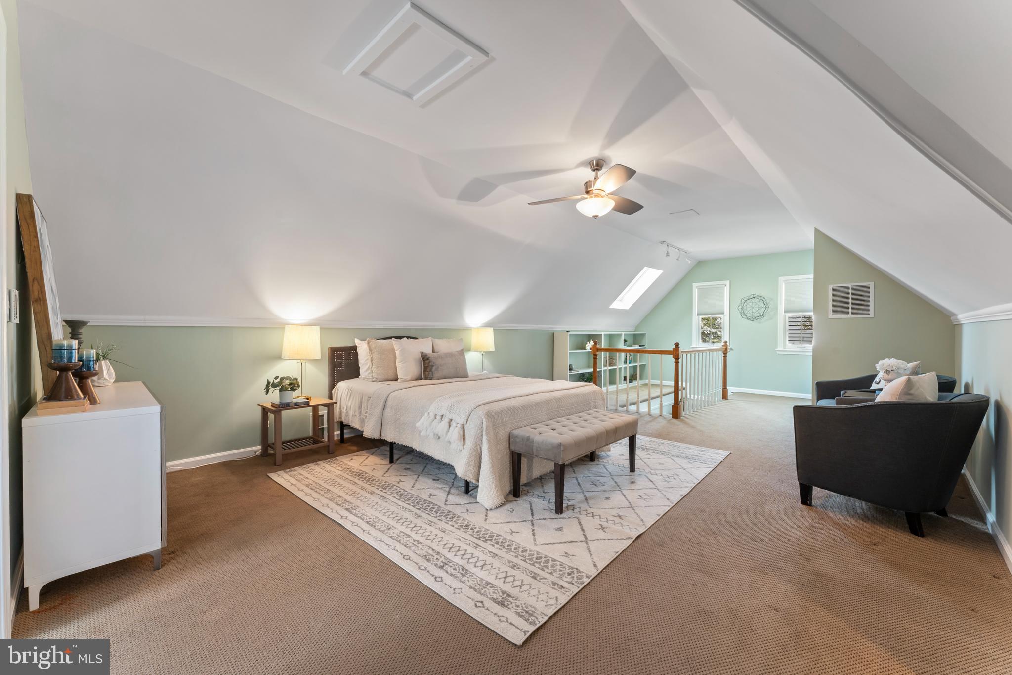9906 Rogart Road Silver Spring, MD 20901 - Photo 36 of 68 a spacious bedroom with a bed a couch and a chandelier
