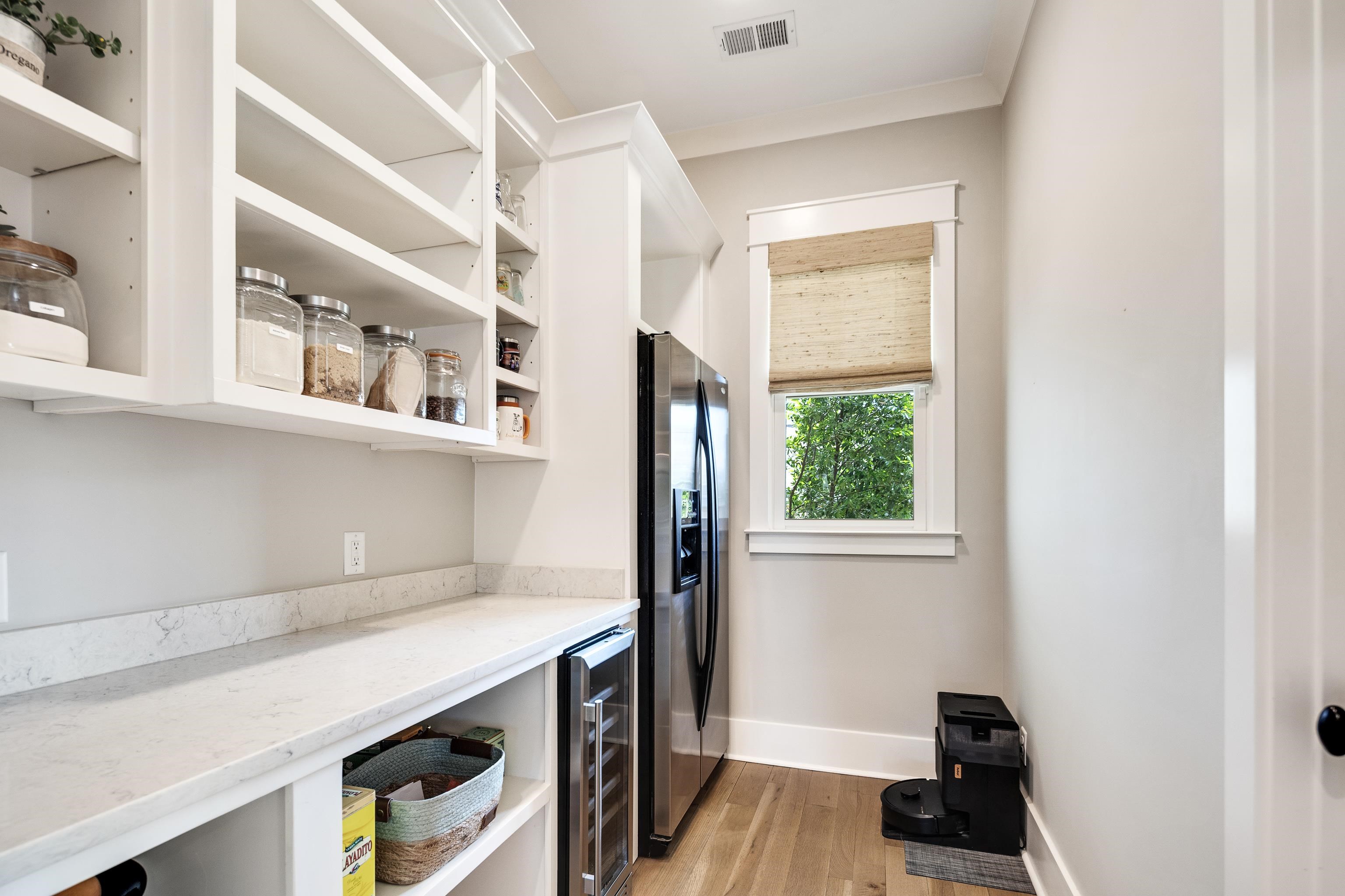 100 Sunflower View Road Piperton, TN 38017 - Photo 12 of 29 Spacious pantry featuring extensive open shelving, light-toned countertops, wood-finish flooring, a stainless steel refrigerator, and an integrated beverage cooler