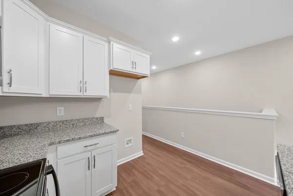 a kitchen with granite countertop white cabinets and a sink