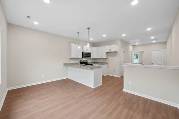 a kitchen with a refrigerator and white cabinets