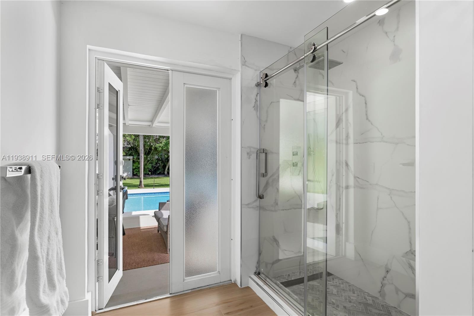 7825 Southwest 72nd Avenue Miami, FL 33143 - Photo 30 of 30 a bathroom with a glass shower door and a mirror