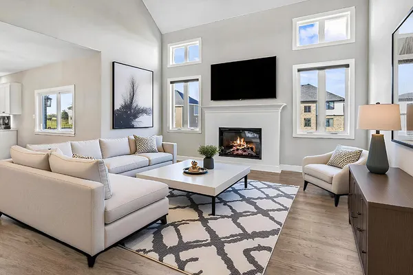 a living room with furniture a flat screen tv and a fireplace