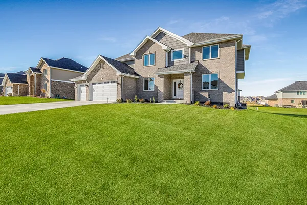 a front view of a house with a yard and garage