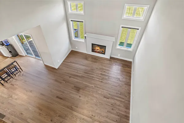 a view of an empty room with window and wooden floor