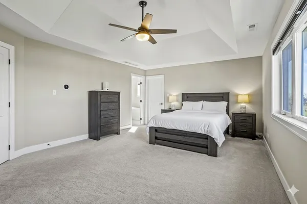 a spacious bedroom with a bed and a ceiling fan