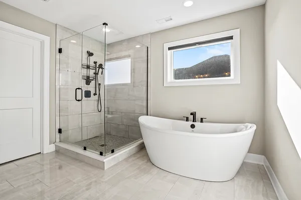 a white bath tub sitting next to a shower