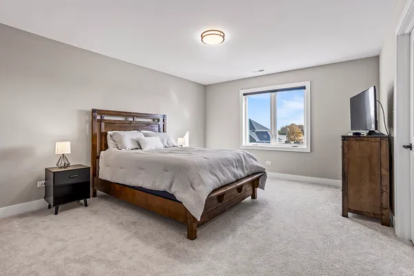 a bedroom with a bed dresser and a window