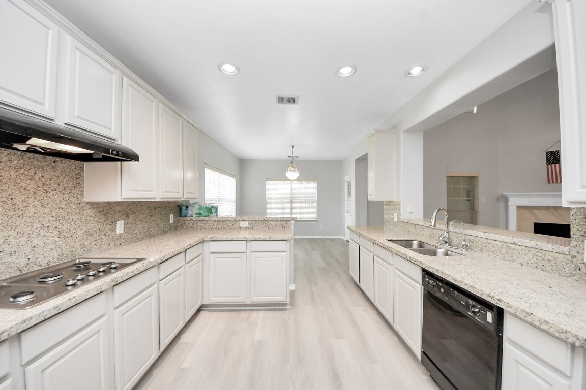 6803 Chapelfield Lane Houston, TX 77049 - Photo 15 of 50 a large white kitchen with stainless steel appliances granite countertop a sink dishwasher a stove and white cabinets with wooden floor