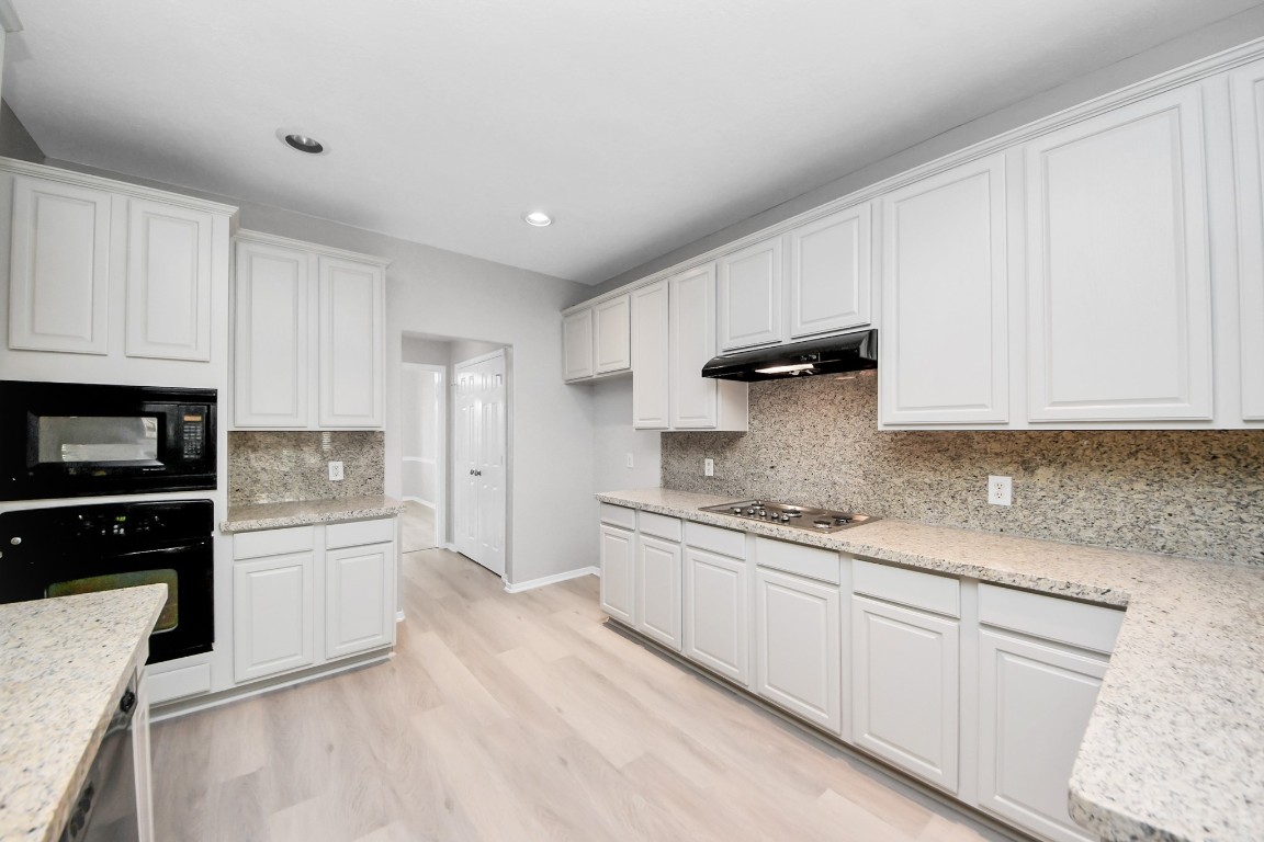 6803 Chapelfield Lane Houston, TX 77049 - Photo 16 of 50 a kitchen with granite countertop white cabinets and stainless steel appliances