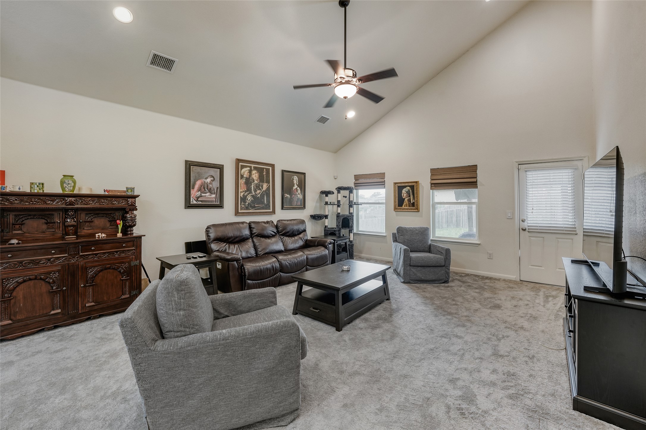 15105 Shell Bark Cove Austin, TX 78724 - Photo 13 of 30 A welcoming living room featuring a vaulted ceiling and a cooling ceiling fan.