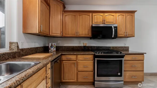 a kitchen with granite countertop a sink and a stove top oven
