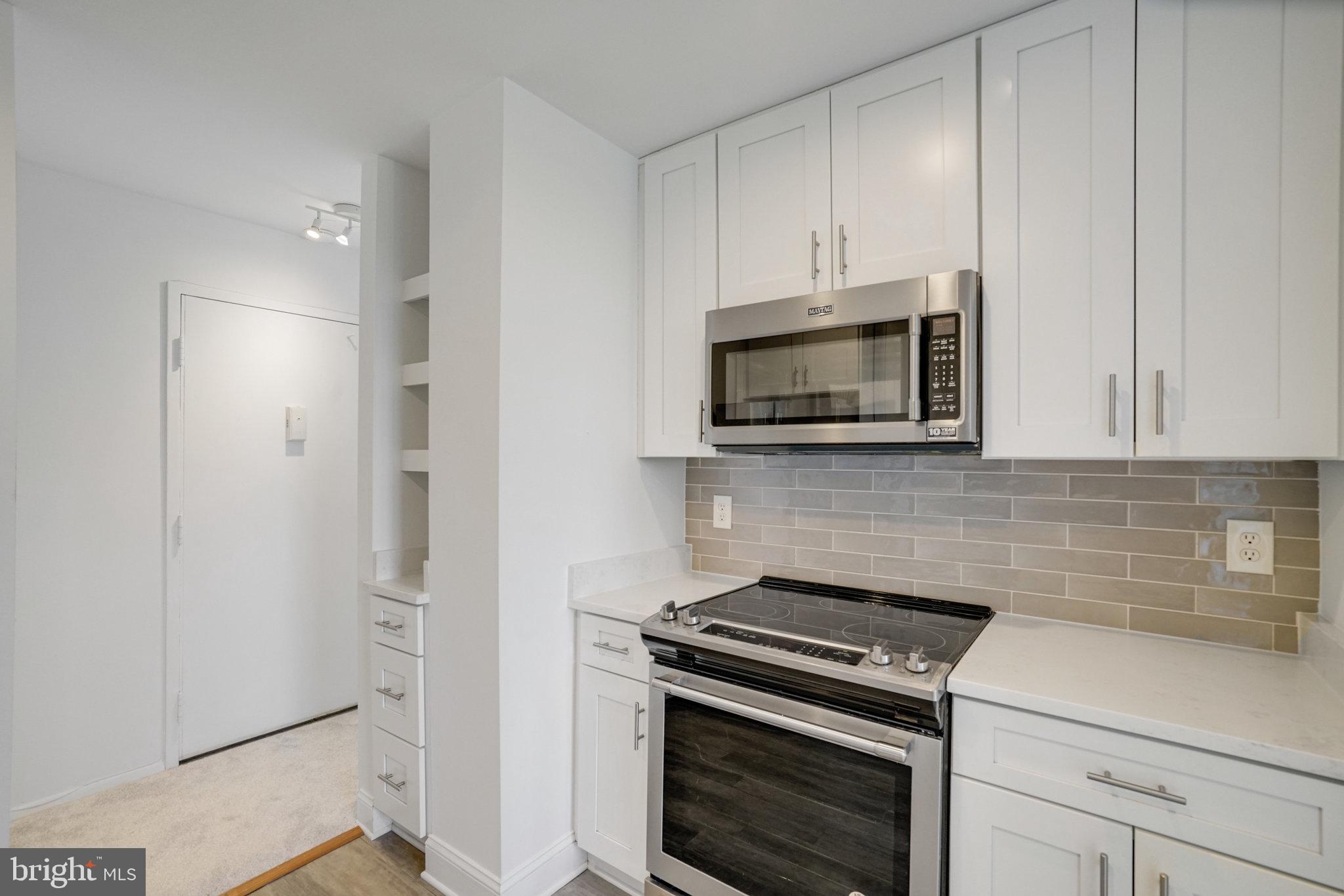 3245 Rio Drive, Unit 901 Falls Church, VA 22041 - Photo 12 of 38 a kitchen with stainless steel appliances a stove a microwave and cabinets