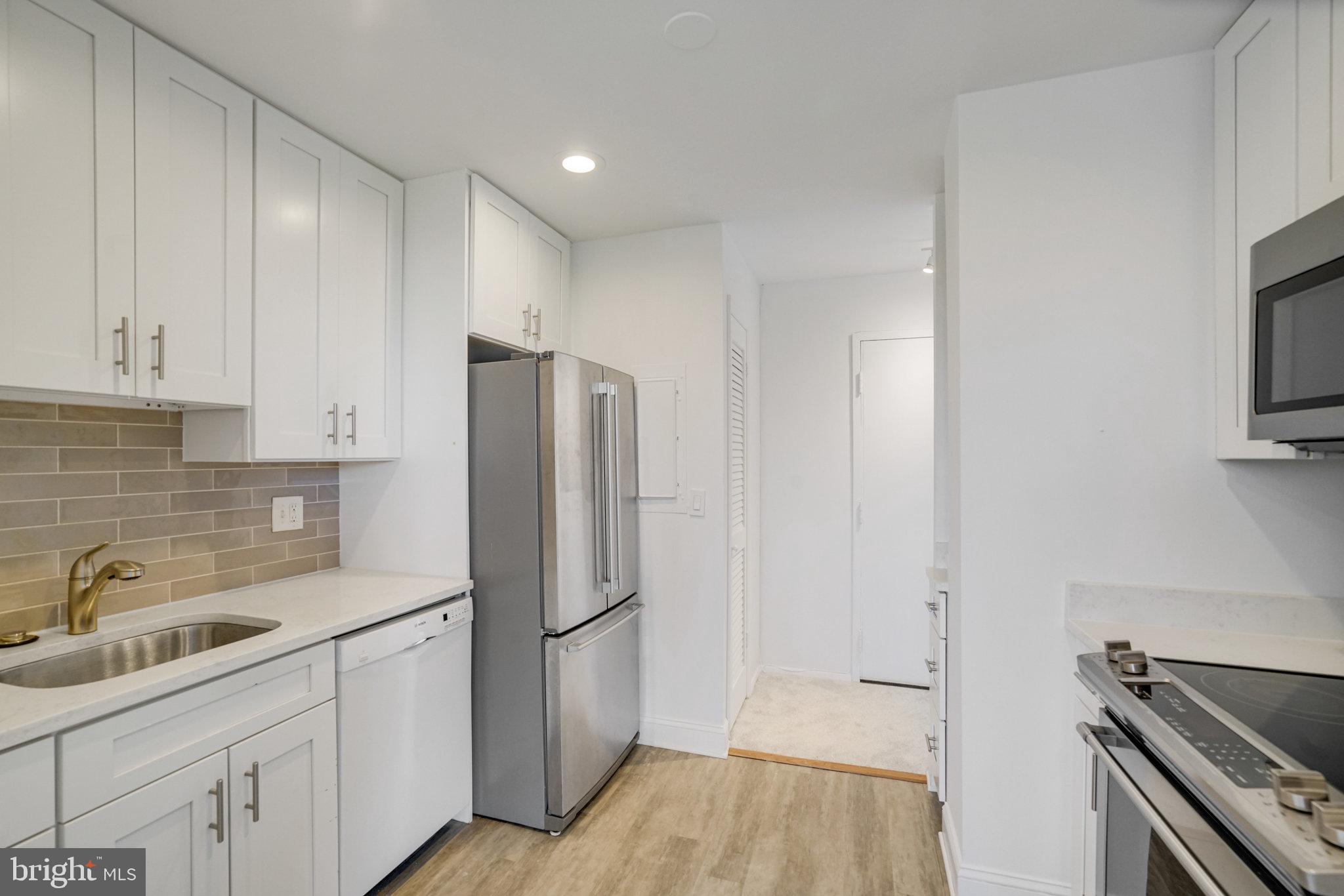 3245 Rio Drive, Unit 901 Falls Church, VA 22041 - Photo 14 of 38 a kitchen with white cabinets and stainless steel appliances