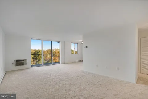 an empty room with windows and closet