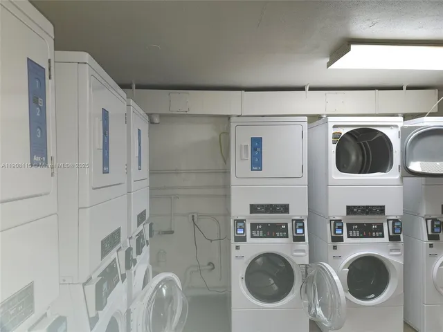 a utility room with dryer washer and a view of kitchen