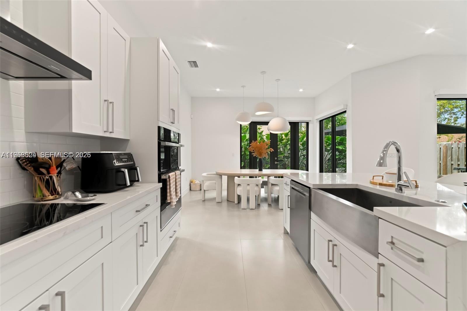 7771 Southwest 99th Street Miami, FL 33156 - Photo 18 of 33 a kitchen with counter top space a sink stainless steel appliances and windows