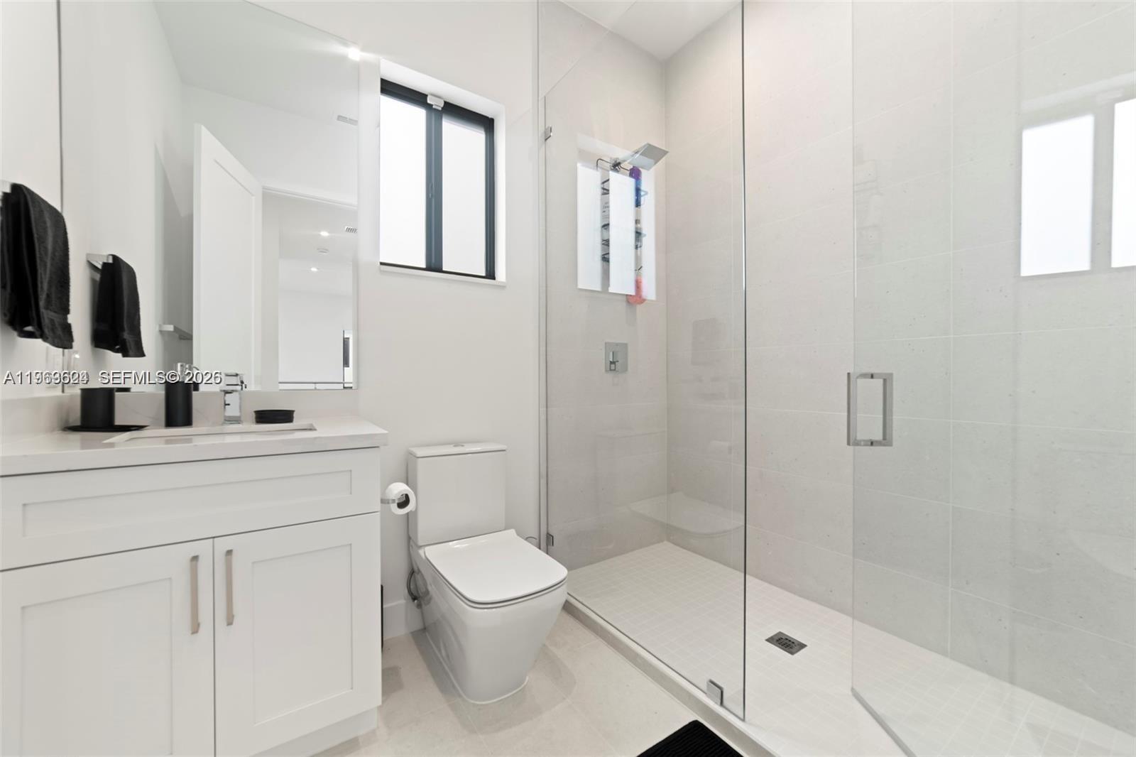 7771 Southwest 99th Street Miami, FL 33156 - Photo 21 of 33 a bathroom with a shower a sink a toilet and mirror
