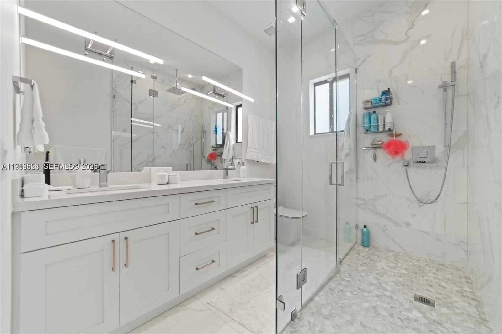 7771 Southwest 99th Street Miami, FL 33156 - Photo 29 of 33 a bathroom with a double vanity sink mirror and shower
