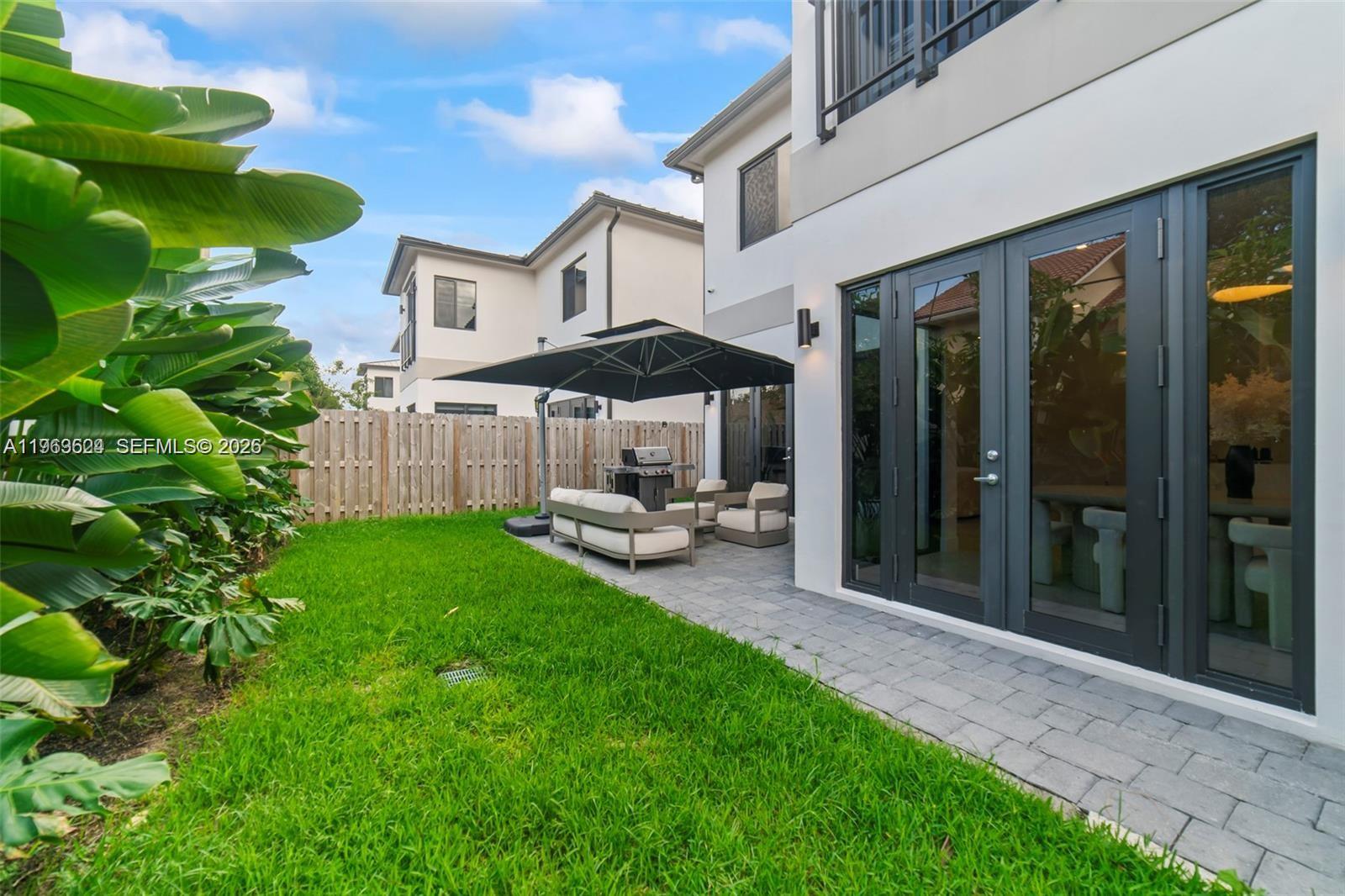 7771 Southwest 99th Street Miami, FL 33156 - Photo 6 of 33 a view of a patio with table and chairs under an umbrella