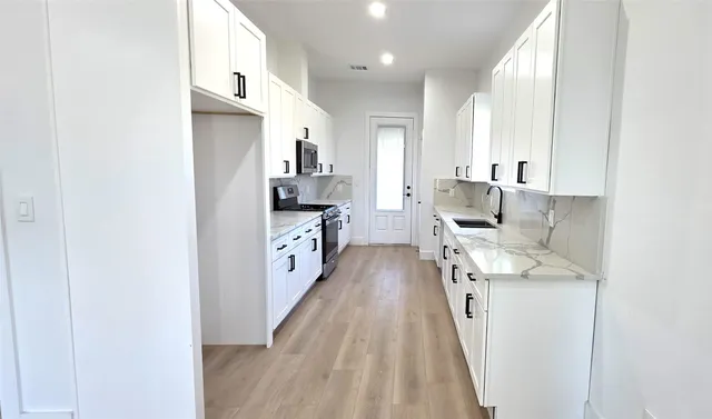 a kitchen with stainless steel appliances a sink and a refrigerator
