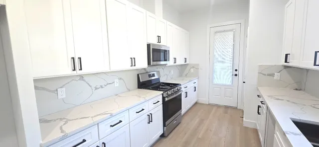 a kitchen with white cabinets and stainless steel appliances