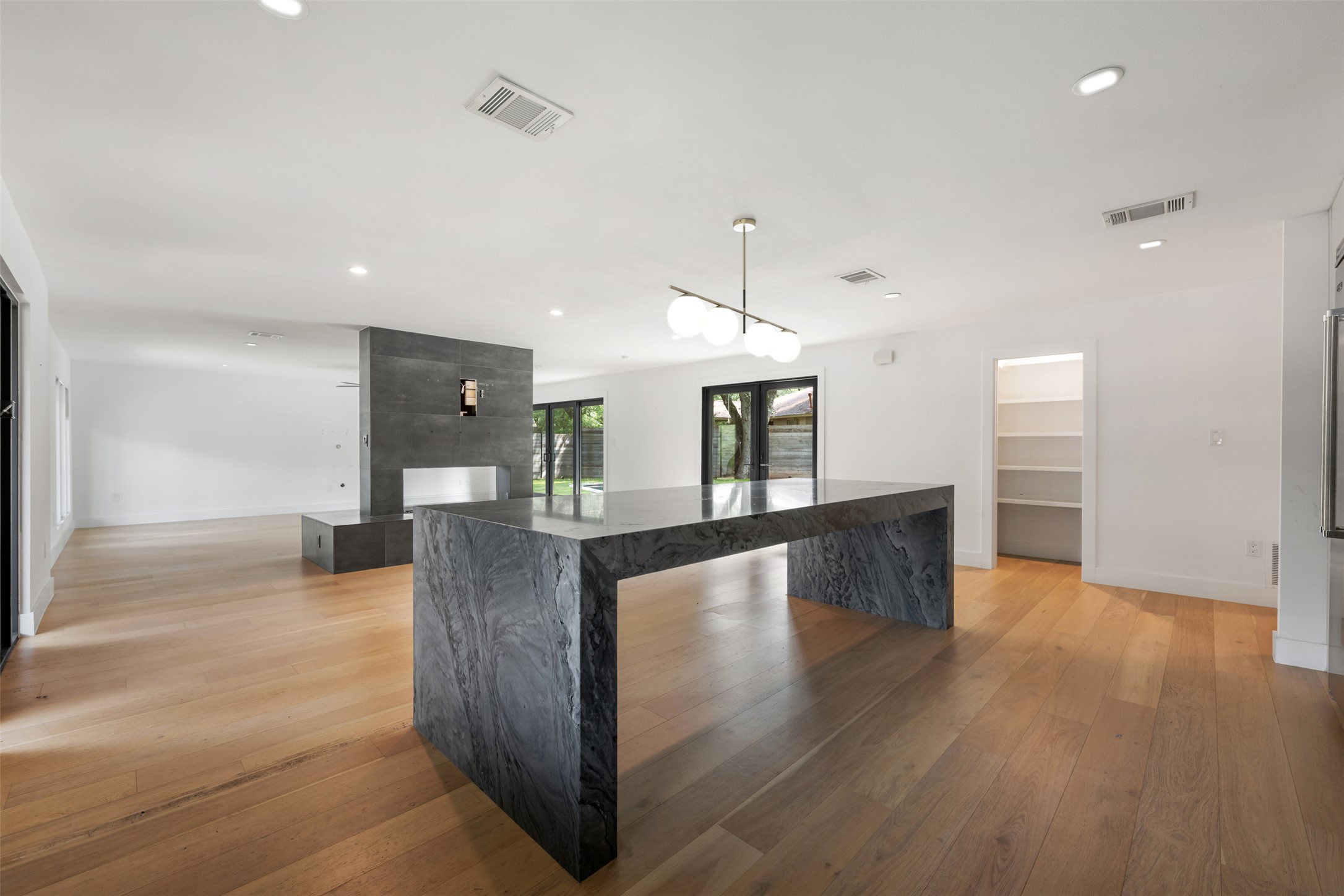 8900 Point W Drive Austin, TX 78759 - Photo 16 of 40 A sleek island and modern fireplace anchor this open-concept space with lustrous hardwood floors.