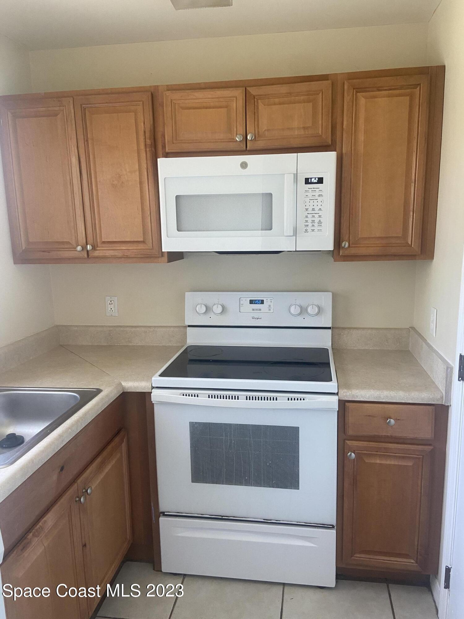 290 Spring Drive, Unit 4 Merritt Island, FL 32953 - Photo 3 of 16 a stove top oven sitting inside of a kitchen
