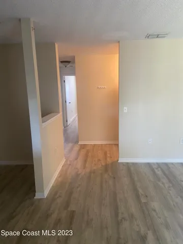 an empty room with wooden floor and a bathroom