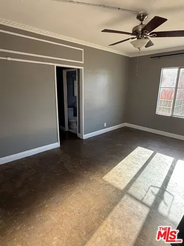 en empty room with windows and ceiling fan